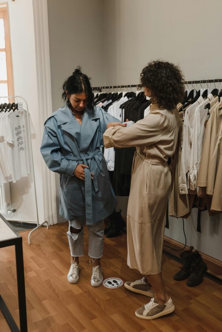 Two women engaging in fashion shopping, trying on clothes in a boutique.